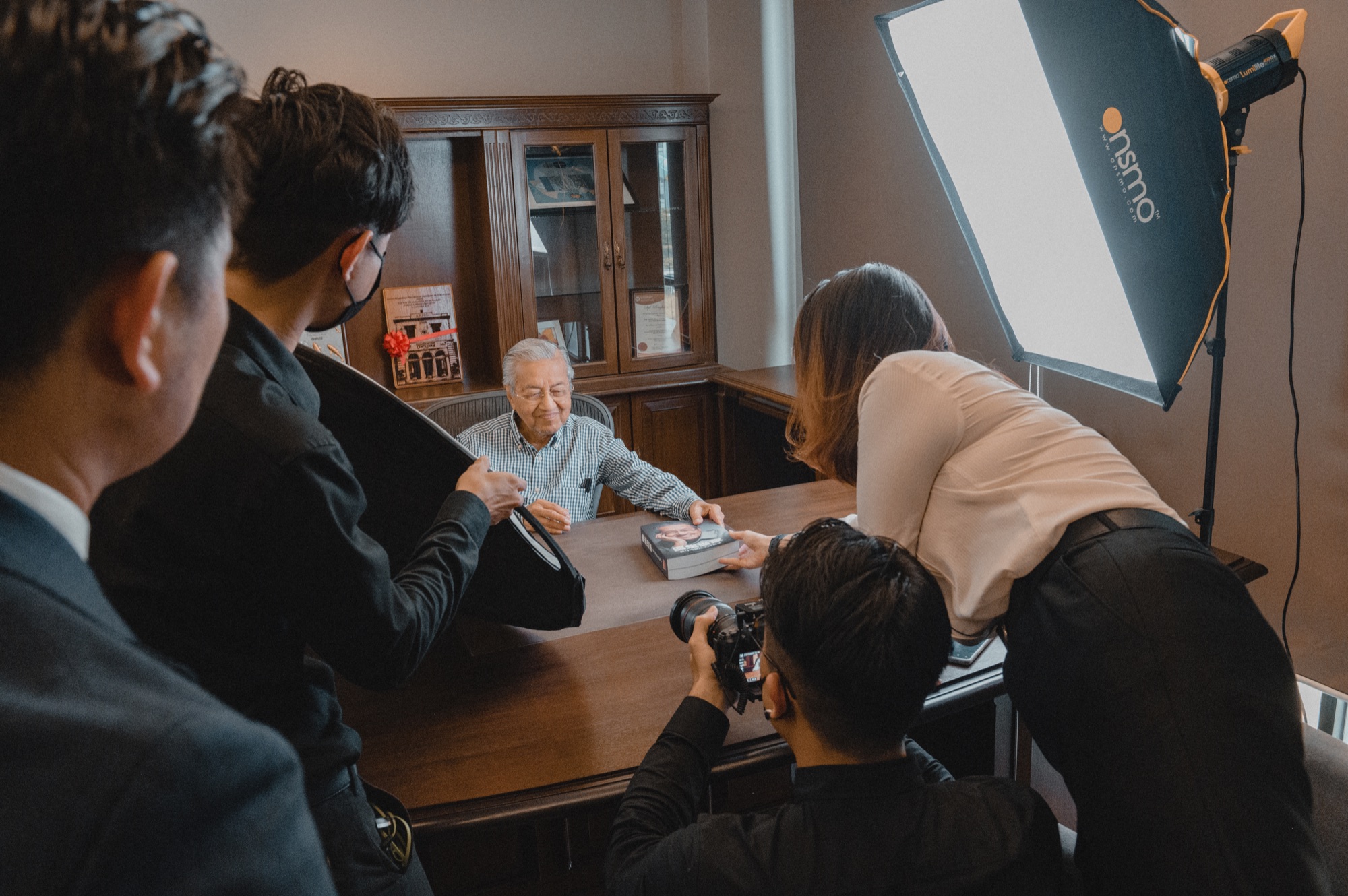 The production team gathered around Tun Mahathir during the shoot