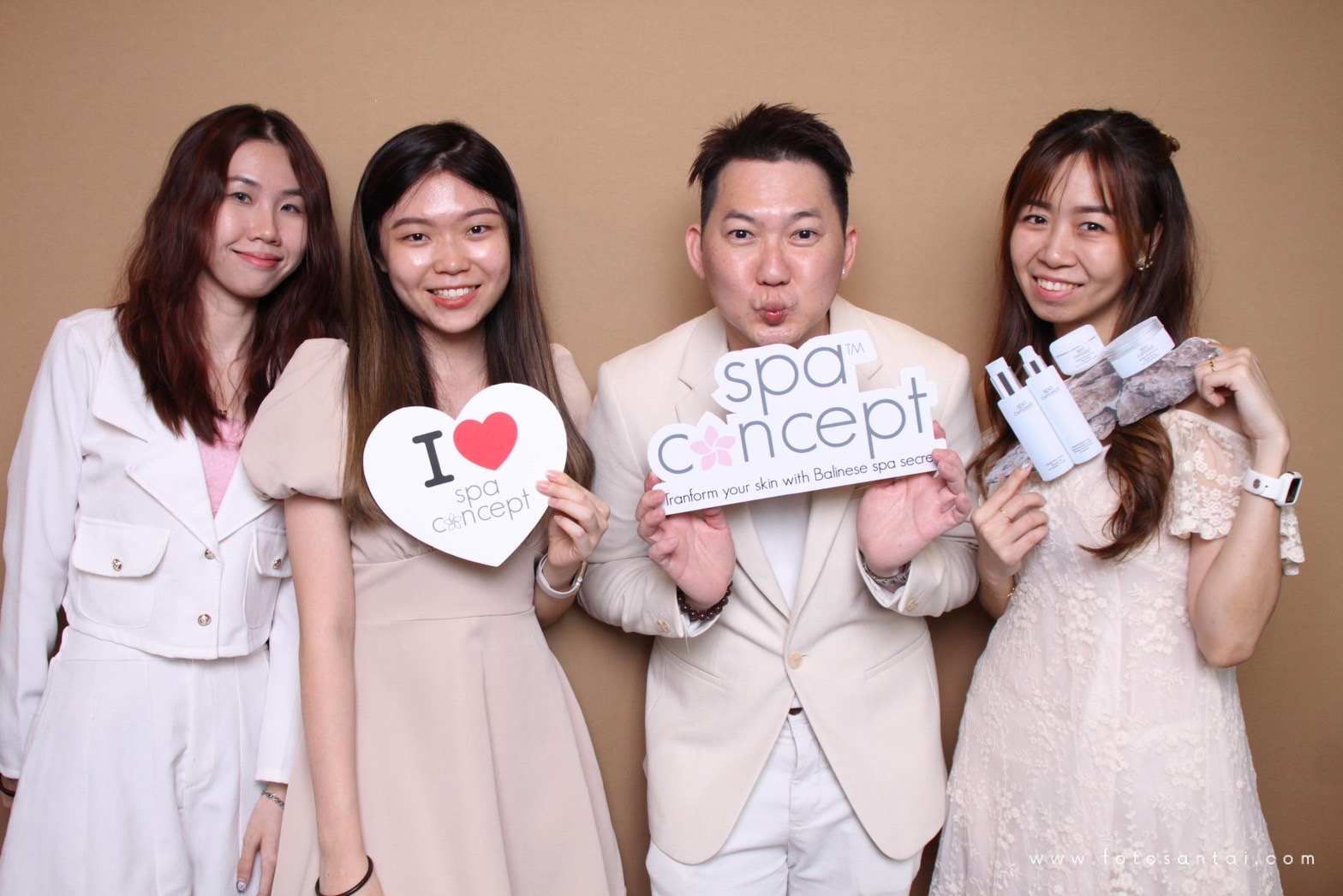 Four guests holding SpaConcept branded signs and product props
